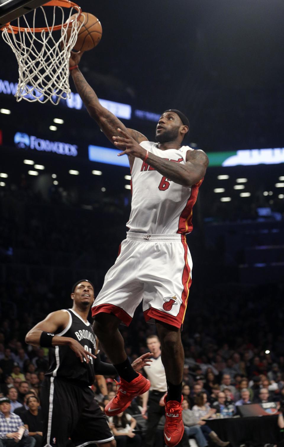 Miami Heat's LeBron James (6) drives past Brooklyn Nets' Paul Pierce (34) during the first half of an NBA basketball game on Friday, Jan. 10, 2014, in New York. (AP Photo/Frank Franklin II)