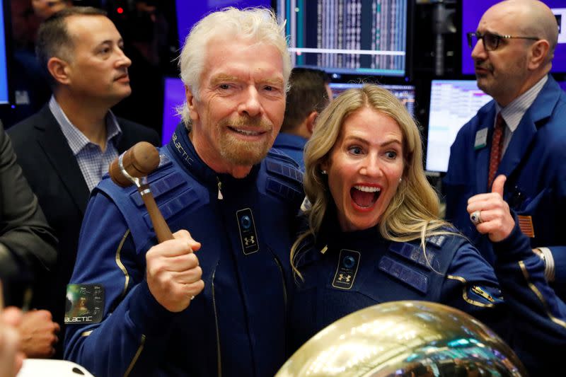 FILE PHOTO: Sir Richard Branson poses on floor of New York Stock Exchange with Future space traveller Jennifer Rallison from Canada as Virgin Galactic (SPCE) begins public trading in New York