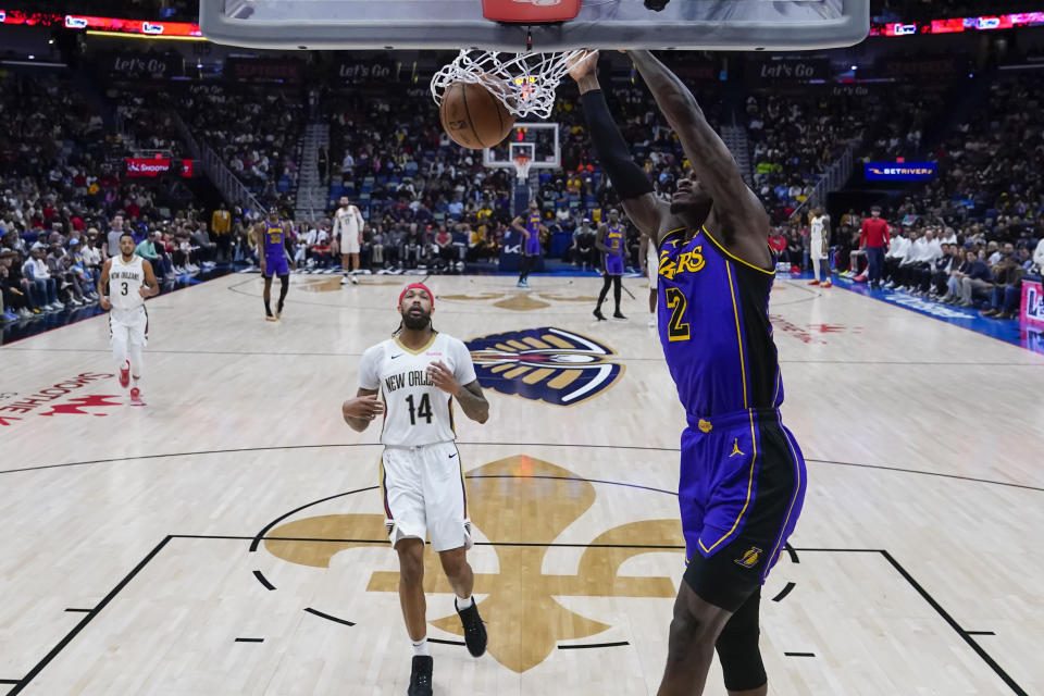 Los Angeles Lakers forward Jarred Vanderbilt (2) slam dunks ahead of New Orleans Pelicans forward Brandon Ingram (14) in the first half of an NBA basketball game in New Orleans, Sunday, Dec. 31, 2023. (AP Photo/Gerald Herbert)