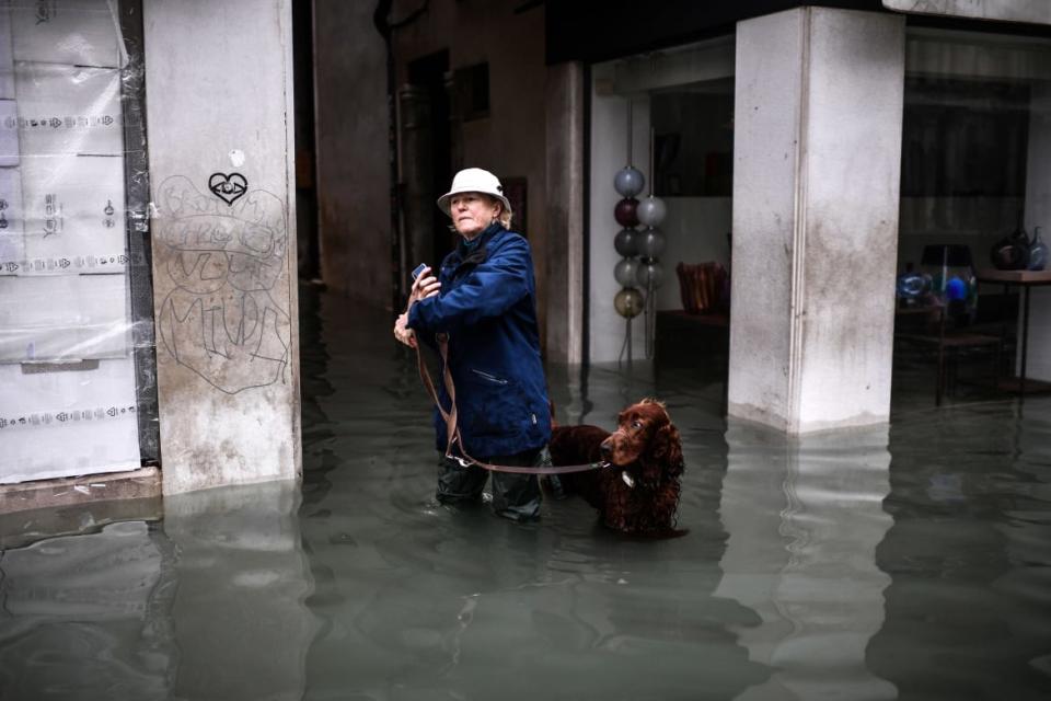 <div class="inline-image__caption"><p>A woman walks her dog in the flooded city. High waters inundated 85 percent of the lagoon city, causing widespread damage to homes and businesses. </p></div> <div class="inline-image__credit">Marco Bertorello/Getty</div>