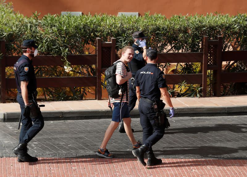 Police officers walk outside H10 Costa Adeje Palace, which is on lockdown after cases of coronavirus have been detected there in Adeje