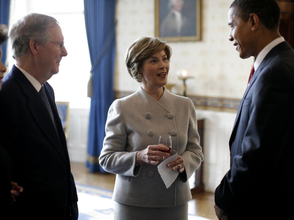 Mitch McConnell, Laura Bush in a grey suit jacket, and Barack Obama.