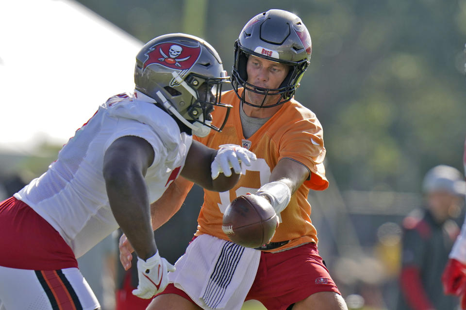 FILE - Tampa Bay Buccaneers quarterback Tom Brady hands off to running back Leonard Fournette during an NFL football training camp practice Saturday, July 30, 2022, in Tampa, Fla. When Brady announced he was ending his brief retirement and returning to the NFL for a 23rd season, Fournette wasn’t caught off guard. Brady, who turned 45 a week into training camp, cited “unfinished business” as one of the reasons for changing his mind. (AP Photo/Chris O'Meara, File)