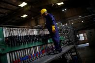 A worker stands next to a lead desulphurisation machine at ACE Green recycling Inc in Ghaziabad