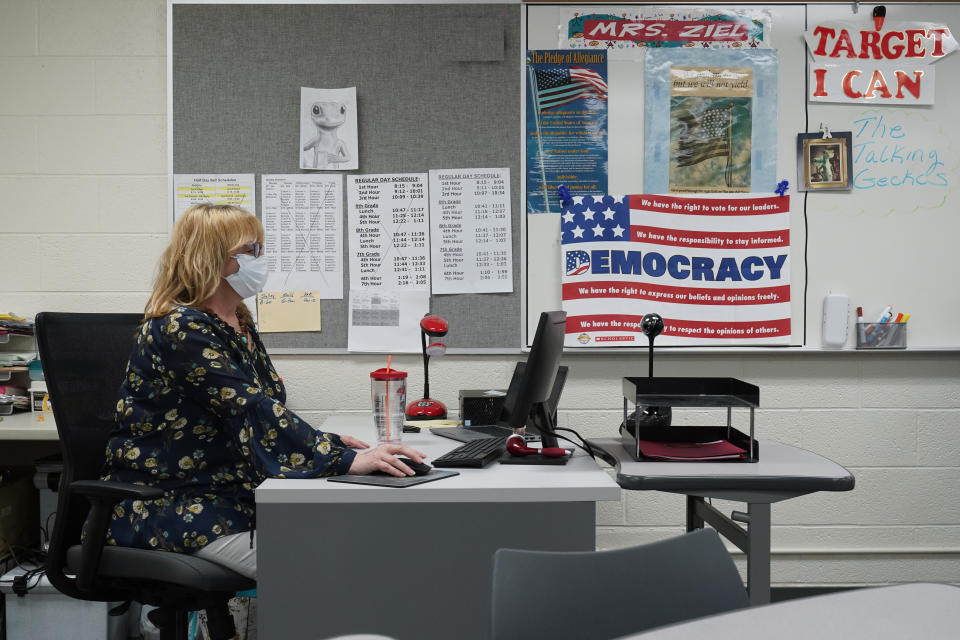 Sue Ziel, a sixth grade social studies teacher at Romeo Middle School, works in her classroom in Romeo, Mich., Tuesday, April 27, 2021. As the pandemic hit, she initially felt “paralyzed” at the thought of having to teach kids online and in person at the same time. She also got the virus. (AP Photo/Paul Sancya)