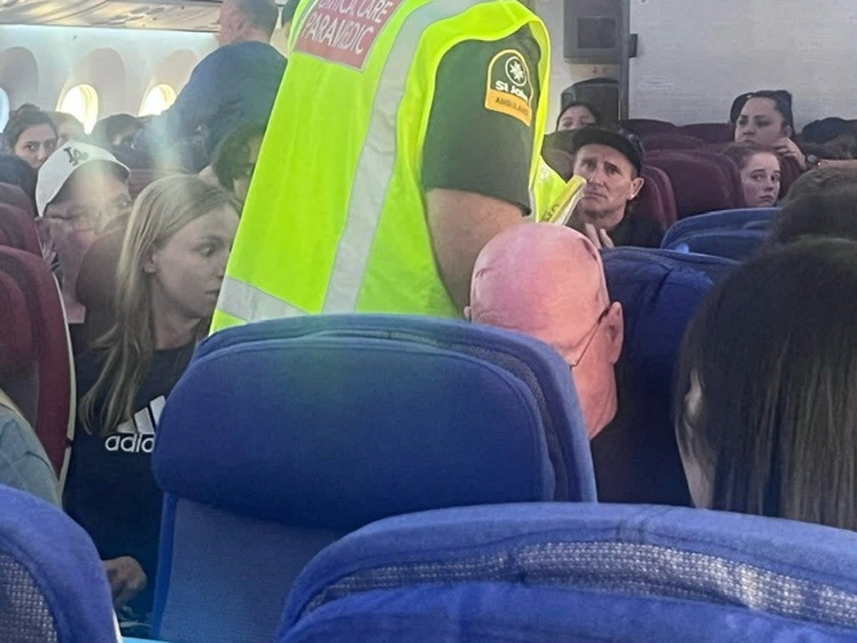 A paramedic walks on board the LATAM Airlines flight that suddenly dropped midair, injuring 50 passengers in March (Brian Adam Jokat via REUTERS)