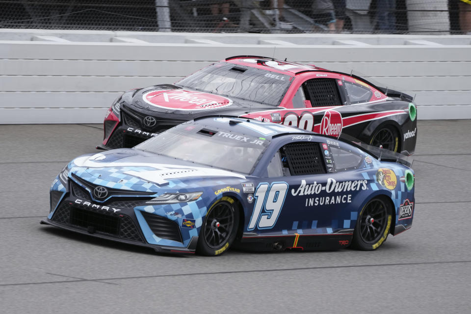Martin Truex Jr. (19) and Christopher Bell (20) battle for position during a NASCAR Cup Series auto race at Michigan International Speedway in Brooklyn, Mich., Sunday, Aug. 6, 2023. (AP Photo/Paul Sancya)