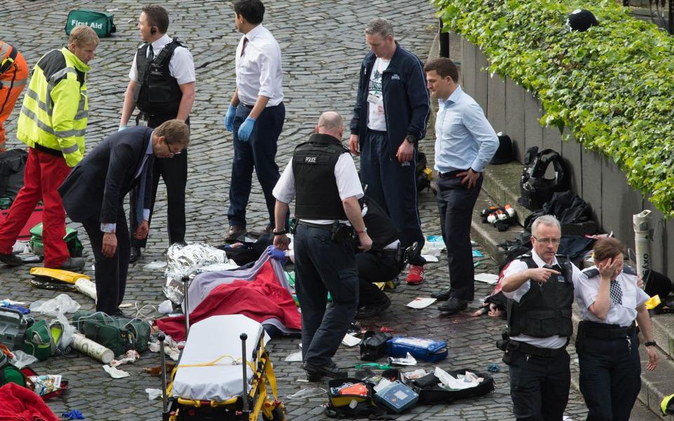 Conservative MP Tobias Ellwood (left) stands amongst the emergency services at the scene outside the Palace of Westminster - Credit: Stefan Rousseau/PA