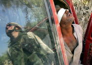 An Iraqi man suspected of having explosives in his car is held after being arrested by the U.S army near Baquba, Iraq, October 15, 2005. [Iraqis headed to the polls in an historic referendum on Saturday, with up to 15 million eligible voters deciding on a controversial new post-Saddam Hussein constitution that its backers hope will unite the torn country. Amid intense security, including a ban on all traffic, voters flowed on foot to polling stations across Baghdad.] REUTERS