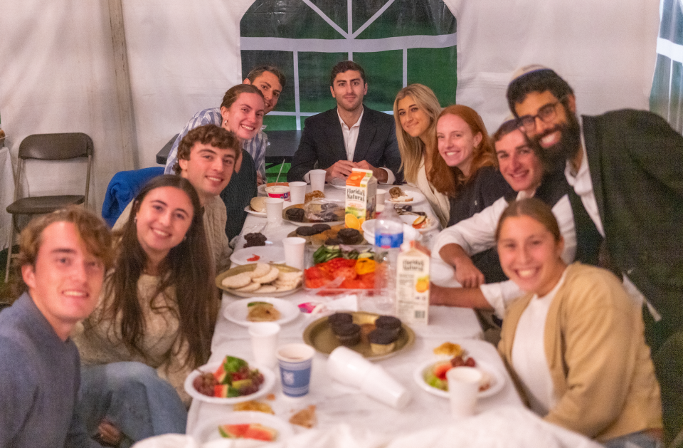 Rabbi Didy Waks and Hamilton College students enjoy weekly Friday night Shabbat dinner.