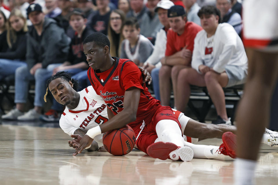 Eastern Washington's Imhotep George (25) and Texas Tech's Davion Warren (2) dive on the court for the ball during the first half of an NCAA college basketball game on Wednesday, Dec. 22, 2021, in Lubbock, Texas. (AP Photo/Brad Tollefson)