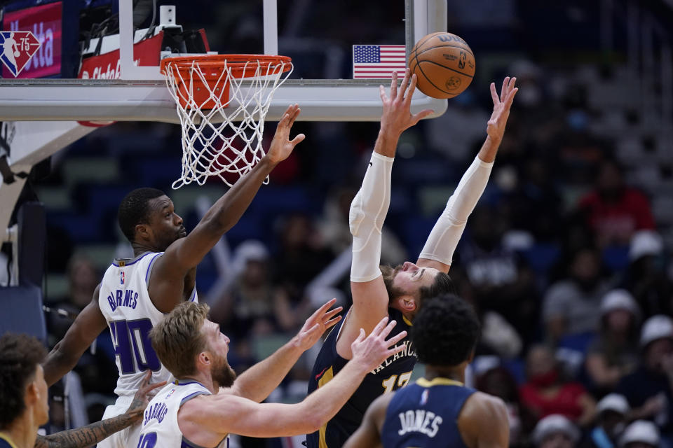 New Orleans Pelicans center Jonas Valanciunas leaps for a rebound against Sacramento Kings forward Harrison Barnes (40) in the second half of an NBA basketball game in New Orleans, Wednesday, March 2, 2022. The Pelicans won 125-95. (AP Photo/Gerald Herbert)