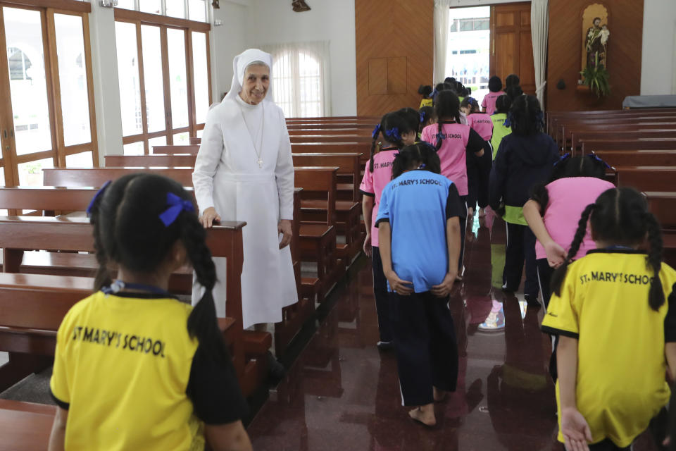 In this Aug. 27, 2019, photo, ST. Mary's School Vice Principal Sister Ana Rosa Sivori, second left, watches as students leave a church at the girls' school in Udon Thani, about 570 kilometers (355 miles) northeast of Bangkok, Thailand. Sister Ana Rosa Sivori, originally from Buenos Aires in Argentina, shares a great-grandfather with Jorge Mario Bergoglio, who, six years ago, became Pope Francis. So, she and the pontiff are second cousins. (AP Photo/Sakchai Lalit)