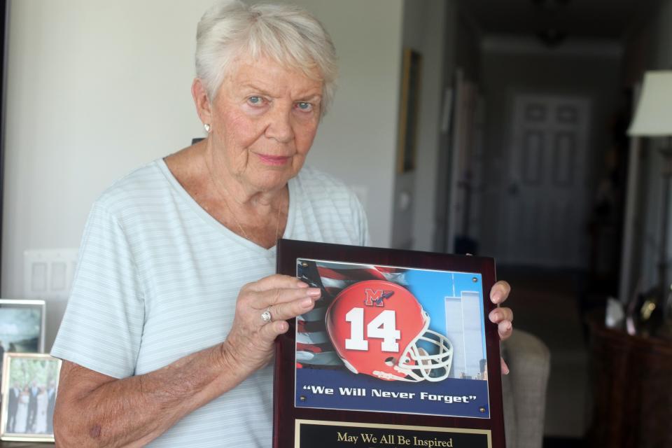 Janet Gray holds a plaque dedicated to her son Chris Gray, a former Manalapan High School football standout who died in the Twin Towers on 9/11