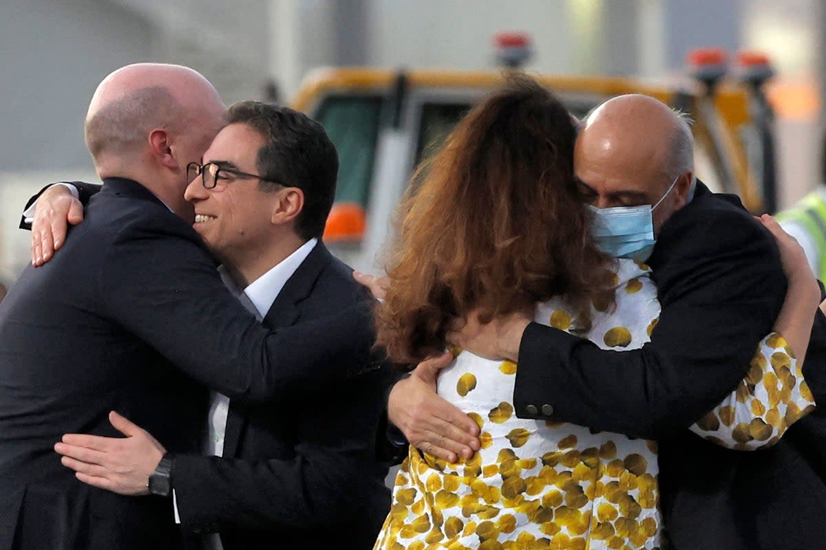 Mr Tahbaz (R, wearing mask) is welcomed on the tarmac at Doha airport after his release from Iran. (AFP via Getty Images)