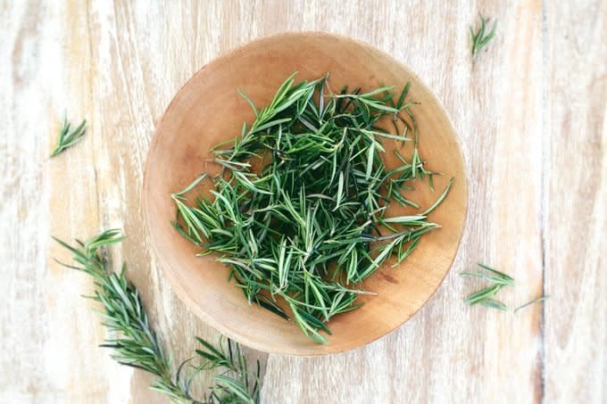 Fresh Rosemary In Bowl On Wooden Table