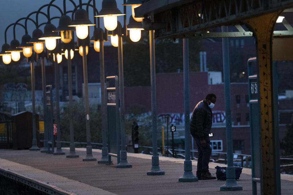 A man waits for a subway in the Woodside neighborhood in the Queens borough of New York, Thursday night, April 23, 2020, during the coronavirus pandemic. Last week, for the first time in New York's history, the trains stopped running in a planned shutdown. Between the hours of 1 a.m. and 5 a.m., the subways and New York's 472 stations began closing for a nightly cleaning to disinfect trains. It is a humbling concession for a swaggering, all-night town that, as much as anything, shows how the coronavirus pandemic has seized the gears of New York, one of the world's hardest-hit cities. (AP Photo/Mark Lennihan)
