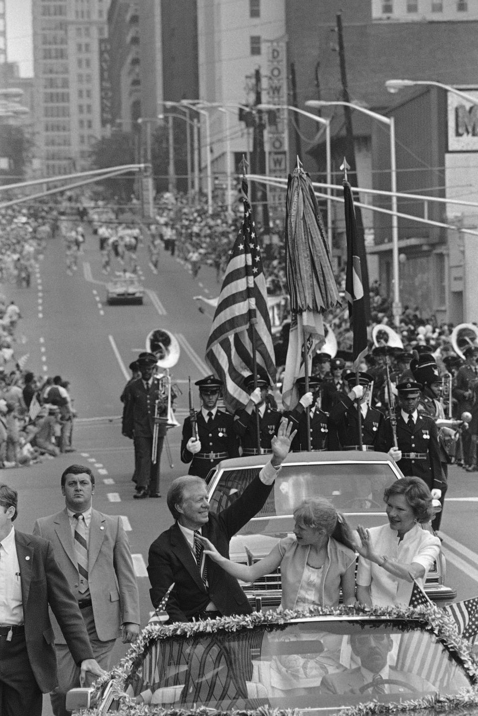 FILE - Former President Jimmy Carter his wife Rosalynn Carter, right, and daughter Amy Carter, wave to the crowd along Peachtree Street as they lead a parade through the streets in Atlanta, Ga., July 4, 1981. Carter was the Grand Marshal in the Independence Day celebration. (AP Photo/Gary Gardiner, File)