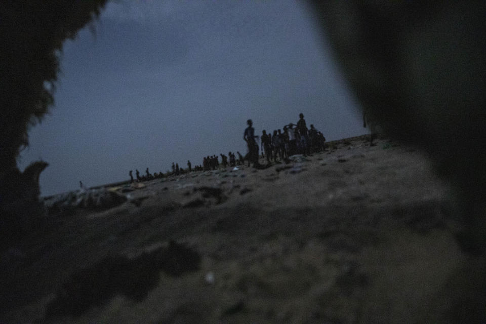 In this July 15, 2019 photo, Ethiopian migrants stand in line to board a boat on the uninhabited coast outside the town of Obock, Djibouti, the shore closest to Yemen. (AP Photo/Nariman El-Mofty)
