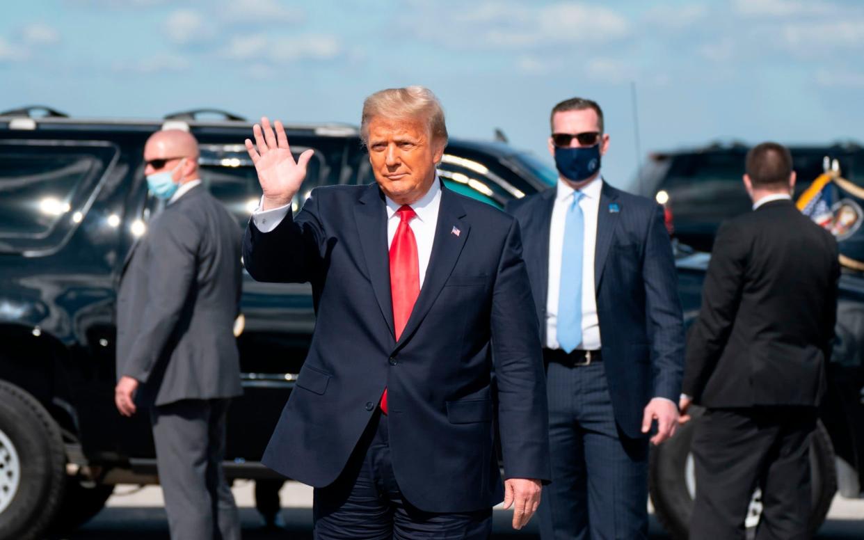 Outgoing US President Donald Trump waves after landing at Palm Beach International Airport in West Palm Beach, Florida - AFP