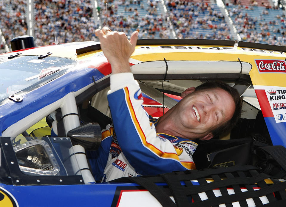 FILE - In this July 13, 2007, file photo, John Andretti smiles as he climbs from his car after qualifying for the NASCAR auto race at Chicagoland Speedway in Joliet, Ill. Andretti, a member of one of racing's most families, has died following a battle with colon cancer, according to a Twitter post from Andretti Autosports on Wednesday, Jan. 30, 2020. He was 56. (AP Photo/Warren Wimmer< File)