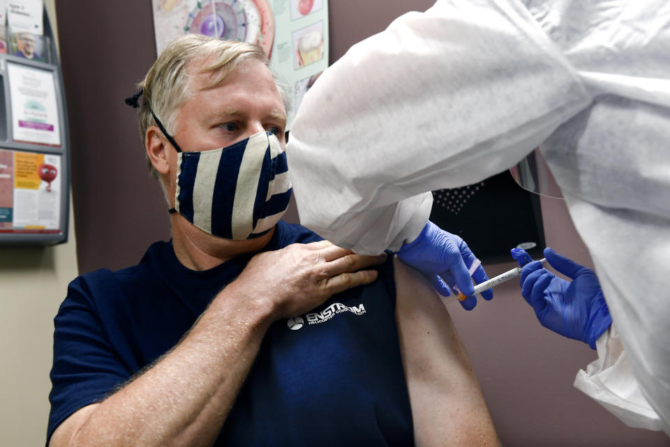 Nurse Carolyn Grausgruber gives volunteer Ithaca firefighter Wade Bardo, of Erin, N.Y., an injection as the world's biggest study of a possible COVID-19 vaccine, developed by the National Institutes of Health and Moderna Inc., gets underway Monday, July 27, 2020, in Binghamton, N.Y. (AP Photo/Hans Pennink)