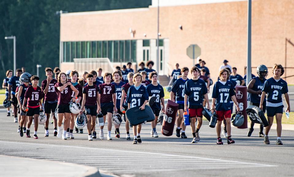 Fountain Inn High School players head to the field for football practice, in Fountain Inn, Friday, July 29, 2022. 