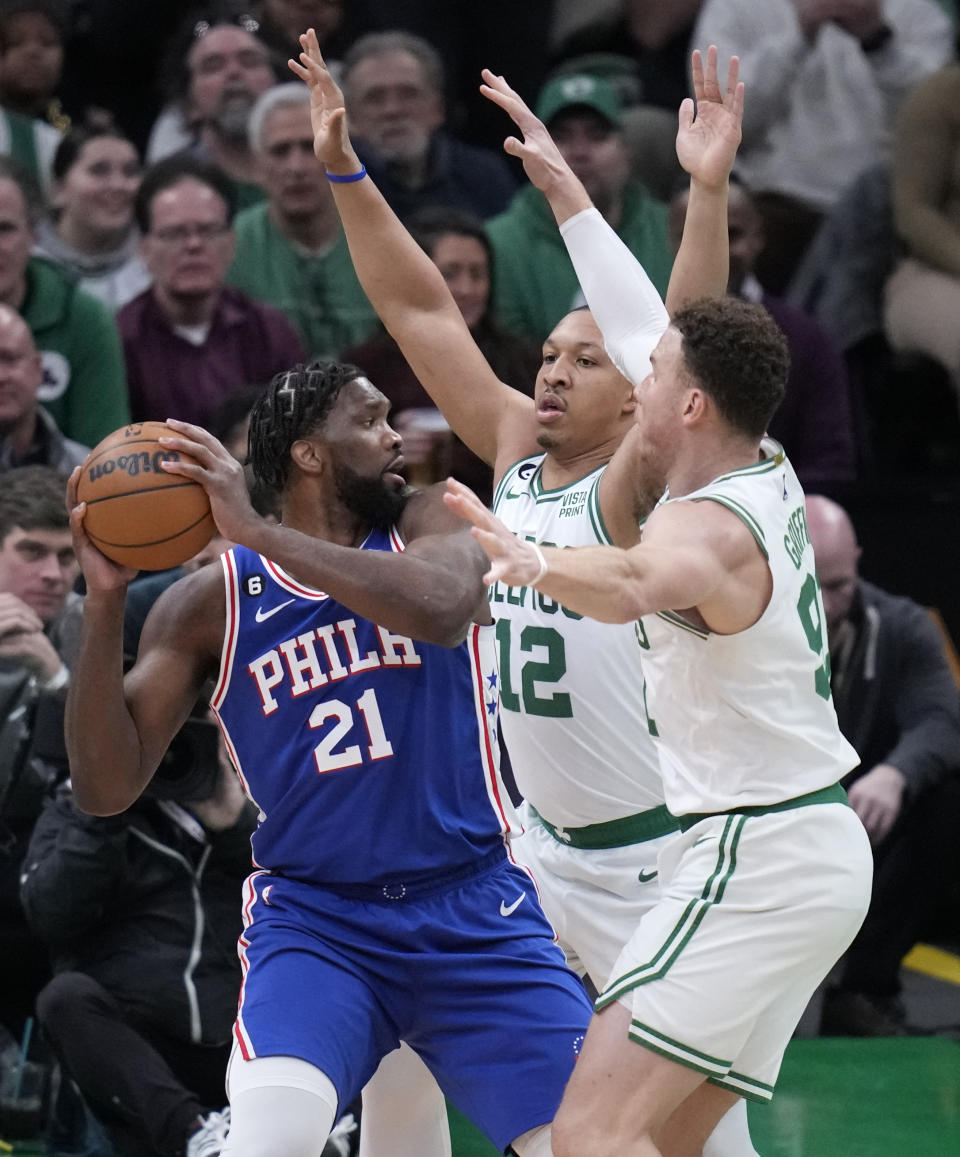 Philadelphia 76ers center Joel Embiid (21) is trapped by Boston Celtics' Grant Williams (12) and Blake Griffin, right, during the first half of an NBA basketball game, Wednesday, Feb. 8, 2023, in Boston. (AP Photo/Charles Krupa)