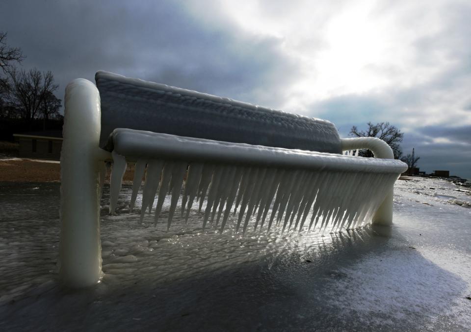 Layers of ice coat a bench at Lions Park as the sun peeks through clouds on Jan. 11, 2019, along the shores of Lake Michigan in St. Joseph, Michigan.