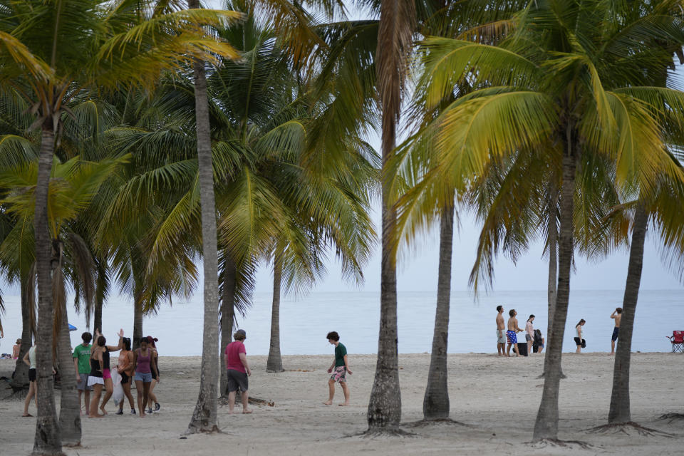 People enjoy the beach in Crandon Park, Friday, July 28, 2023, in Key Biscayne, Fla. Humans naturally look to water for a chance to refresh, but when water temperatures get too high, some of the appeal is lost. (AP Photo/Rebecca Blackwell)