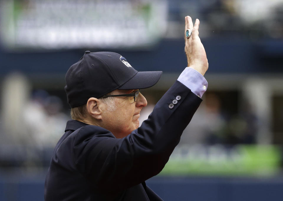 In this Sept. 17, 2017 photo, Seattle Seahawks owner Paul Allen waves as he is honored for his 20 years of team ownership before an NFL football game against the San Francisco 49ers in Seattle. Allen, who co-founded Microsoft with his childhood friend Bill Gates before becoming a billionaire philanthropist who invested in conservation, space travel, arts and culture and professional sports, died Monday. He was 65. (AP Photo/Elaine Thompson)
