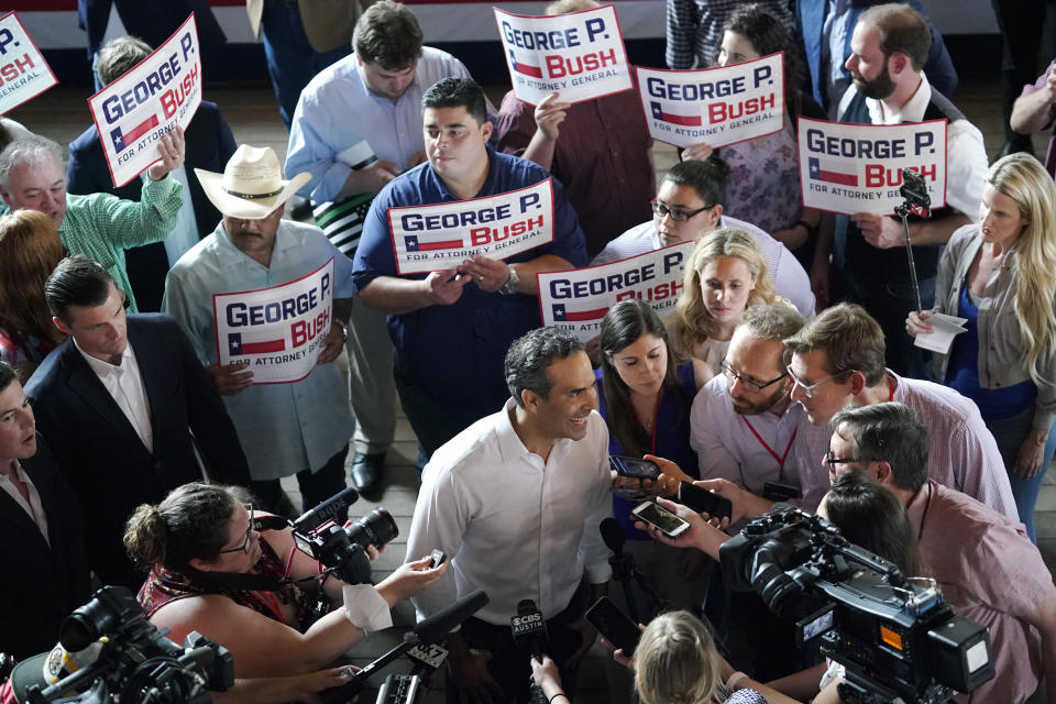 Texas Land Commissioner George P. Bush, center, talks with the media at a kick-off rally where he announced he will run for Texas Attorney General, Wednesday, June 2, 2021, in Austin, Texas. (AP Photo/Eric Gay)