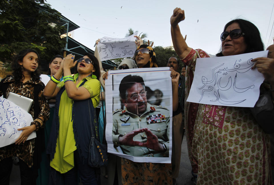 Supporters of Pakistan's former president and military ruler Pervez Musharraf chant slogans in his support in Karachi, Pakistan, Wednesday, April 2, 2014. State-run Pakistan Television said Pakistan’s interior ministry has rejected a request from the country’s former military ruler Pervez Musharraf to go abroad for his own treatment and to see his ailing mother. The placard at right reads, "Salute to great mother." (AP Photo/Fareed Khan)