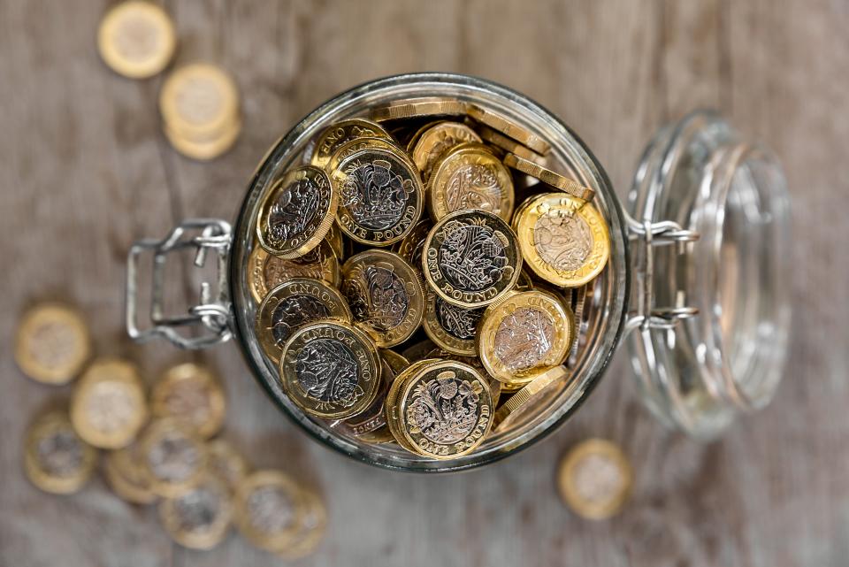 A jar full of saved one pound coins. pensions