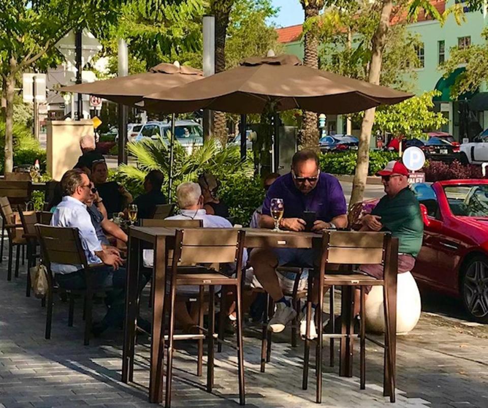 Customers during happy hour at JohnMartin’s Irish pub sit on Miracle Mile in Coral Gables a day before St. Patrick’s Day during the coronavirus crisis.