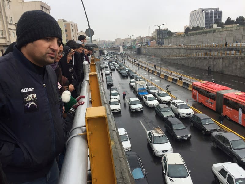 People stop their cars in a highway to show their protest against increased gas price in Tehran