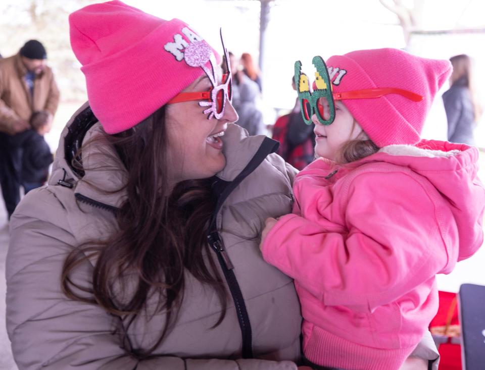 Morgan Broel and her daughter Sophia Broel, 3, try on some Easter-themed glasses before getting into a photo booth at the Jackson Township North Park Easter Egg Hunt.