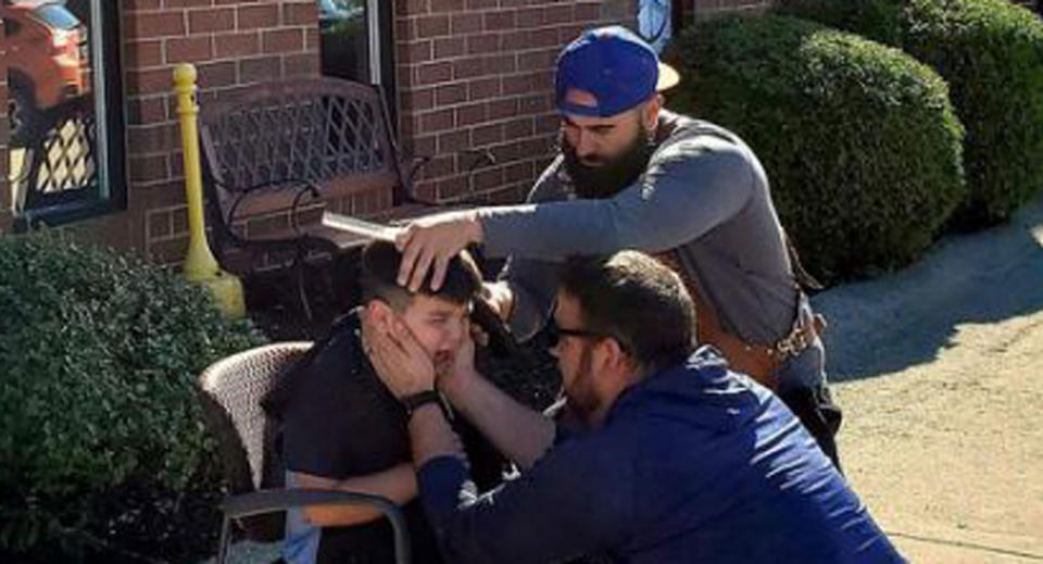 Bryce Juby, 7, gets his haircut by Marco Conti outside Marky Fresh Barbershop while his father Joe holds his face to comfort him.