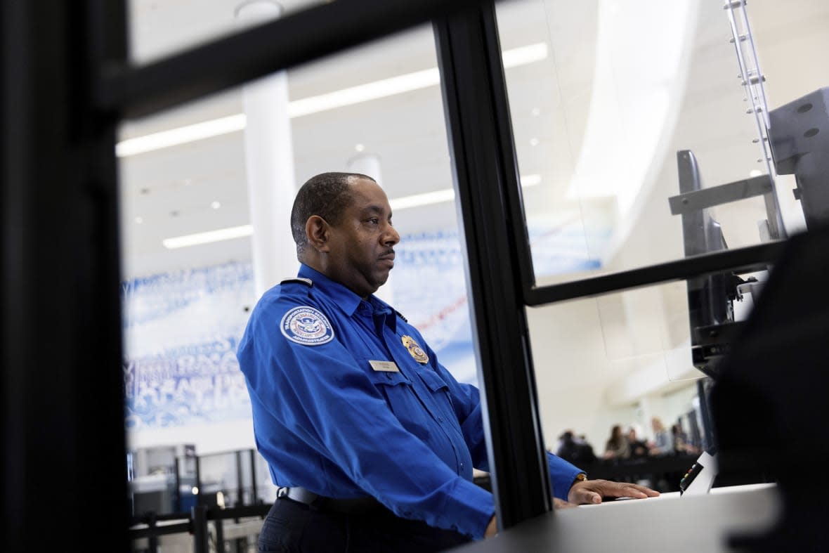 A Transportation Security Administration officer demonstrates new facial recognition technology at a Baltimore-Washington International Thurgood Marshall Airport security checkpoint, Wednesday, April 26, 2023, in Glen Burnie, Md. (AP Photo/Julia Nikhinson)