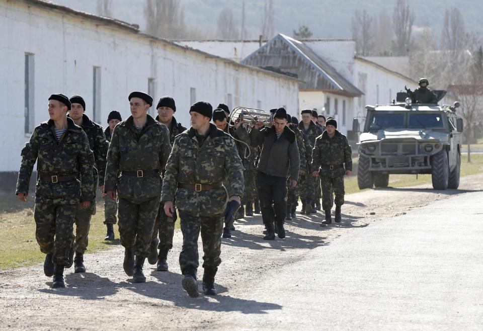 Ukrainian servicemen walk after leaving the territory of their military unit in the village of Perevalnoye outside Simferopol