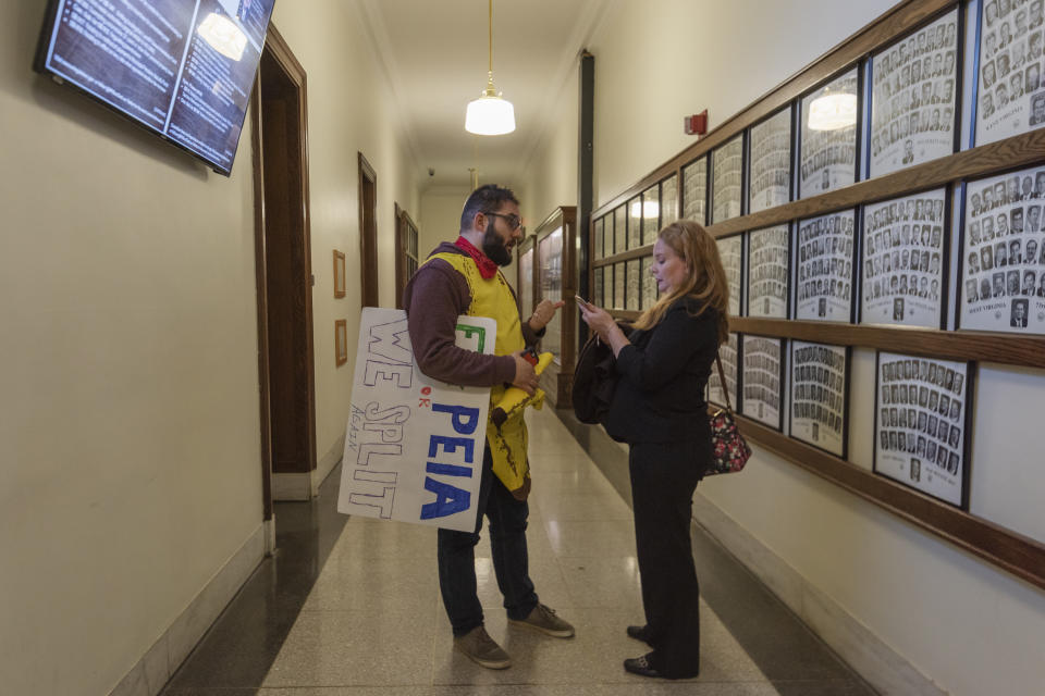 Vera Miller, President of the Cabell County Education Association, speaks with association member and teacher Adam Culver in a hallway adjacent to where leaders of the WVEA, AFT-WV and WVSSPA education unions called for a statewide strike beginning tomorrow at a press conference outside of the Senate chamber at the West Virginia State Capitol in Charleston, W.Va., on Monday, Feb. 18, 2019. (Craig Hudson/Charleston Gazette-Mail via AP)