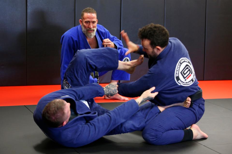 Danny Savery looks on as Eric Correia and Leo Pike grapple at the new Danny Savery Brazilian Jiu-Jitsu on Sarah's Way in Fairhaven.