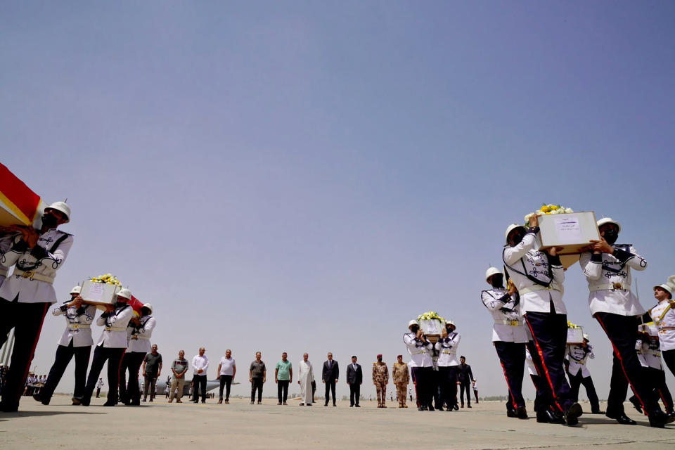 In this photo provided by the Media Office of the Prime Minister of Iraq, Iraqi Prime Minister Mustafa al-Kadhimi, with sunglasses, and relatives of nine people who were killed in an artillery attack blamed on Turkey in the northern Iraqi Kurdish region, attend a ceremony to receive the bodies of the victims as they arrive at Baghdad Airport, Iraq, Thursday, July 21, 2022. Turkey’s foreign minister on Thursday rejected accusations that the country's military carried out the deadly artillery strikes. (Media Office of the Prime Minister of Iraq via AP)
