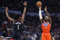 Oklahoma City Thunder guard Luguentz Dort (5) shoots over Houston Rockets forward Amen Thompson (1) during the first half of an NBA basketball game Wednesday, March 27, 2024, in Oklahoma City. (AP Photo/Nate Billings)