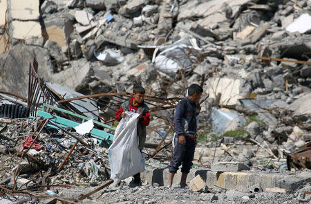 Boys stand on the rubble of damaged buildings in Raqqa, Syria April 18, 2018. REUTERS/Aboud Hamam