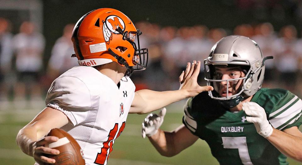 Middleboro QB Jacob Briggs fends off a sack by Dragon Dylan DeAngelis.The Duxbury Dragons hosted the Middleboro Sachems in MIAA football tournament action on Friday November 11, 2022.