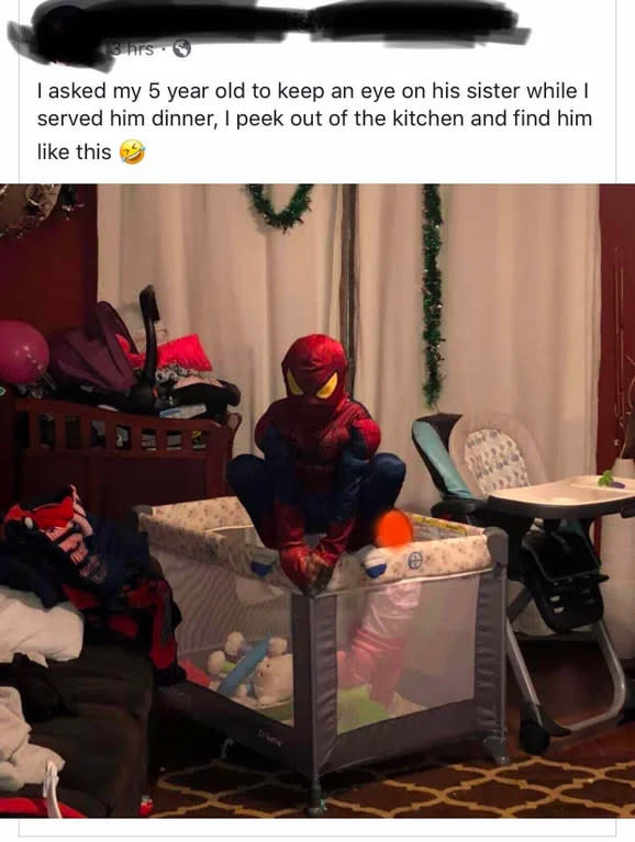 kid dressed as spiderman watching their sibling in a crib