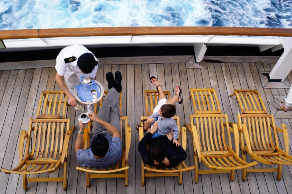 A person serves food to guests on a cruise ship. 