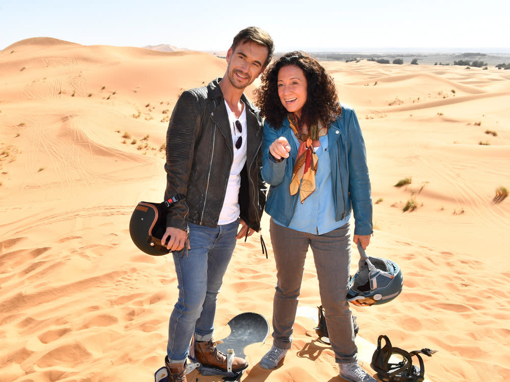 Hanna Liebhold (Barbara Wussow) ist es gelungen, Kapitän Max Parger (Florian Silbereisen) zu einem "Skiausflug" in die goldenen Sanddünen zu überreden (Bild: ZDF / Dirk Bartling)