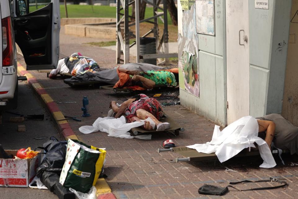 Des Israéliens gisent sur le sol après une attaque du Hamas à Sdérot, en Israël, le 7 octobre 2023. <a href="https://www.gettyimages.com/detail/news-photo/october-2023-israel-sderot-bodies-of-dead-israelis-lie-on-news-photo/1711934608?adppopup=true" rel="nofollow noopener" target="_blank" data-ylk="slk:(Ilia Yefimovich/picture alliance via Getty Images);elm:context_link;itc:0;sec:content-canvas" class="link ">(Ilia Yefimovich/picture alliance via Getty Images)</a>